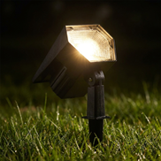 Close-up of solar spike light beam at night in dewy grass
