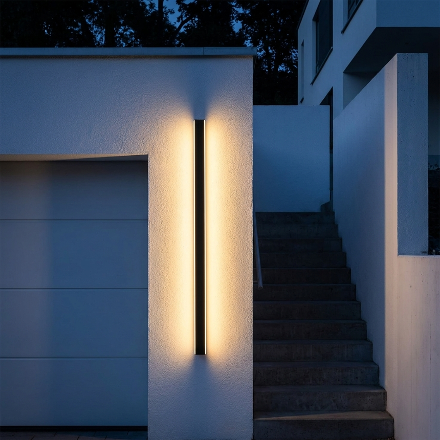 Vertical linear LED bar glowing beside a garage and exterior stairs at night